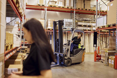 Female forklift operator looking up while working in lumber industry - MASF38214