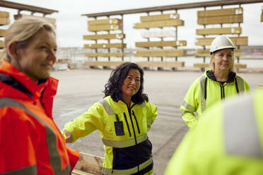 Multiracial female colleagues in protective workwear standing at factory - MASF38257