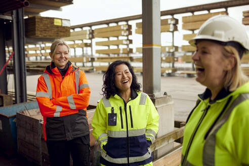 Happy multiracial female workers with colleague at industry - MASF38258