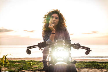Schöne Bikerin auf einem Cafe'-Racer-Motorrad - Hübsches Mädchen fährt Motorrad und genießt den Roadtrip - DMDF03218