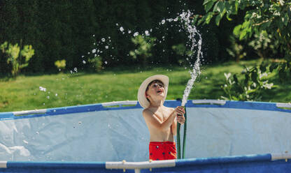 Niedlicher Junge spielt mit Wasserrohr im Schwimmbad - VSNF01329