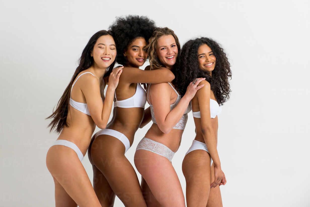 Multi-ethnic group of beautiful women posing in underwear in a beauty  studio - Multicultural fashion models