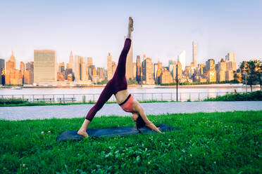 Schöne sportliche Frau macht Yoga-Meditation in einem Park - Mädchen entspannt mit heiterem Ausdruck im Freien - DMDF03284