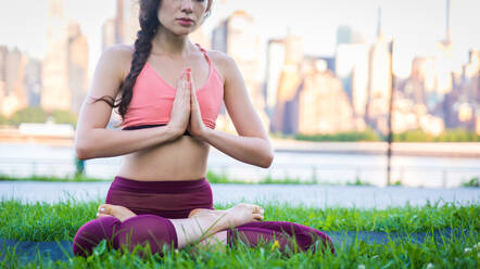 Schöne sportliche Frau macht Yoga-Meditation in einem Park - Mädchen entspannt mit heiterem Ausdruck im Freien - DMDF03286