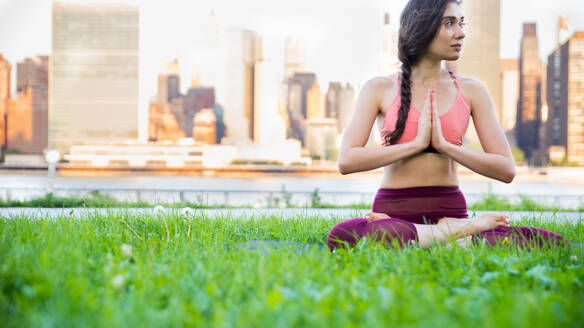 Schöne sportliche Frau macht Yoga-Meditation in einem Park - Mädchen entspannt mit heiterem Ausdruck im Freien - DMDF03287