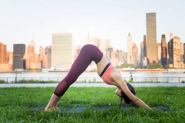 Schöne sportliche Frau macht Yoga-Meditation in einem Park - Mädchen entspannt mit heiterem Ausdruck im Freien - DMDF03288