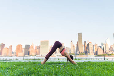 Schöne sportliche Frau macht Yoga-Meditation in einem Park - Mädchen entspannt mit heiterem Ausdruck im Freien - DMDF03291