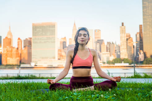 Schöne sportliche Frau macht Yoga-Meditation in einem Park - Mädchen entspannt mit heiterem Ausdruck im Freien - DMDF03295