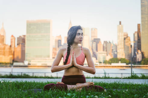 Schöne sportliche Frau macht Yoga-Meditation in einem Park - Mädchen entspannt mit heiterem Ausdruck im Freien - DMDF03299