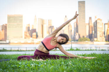 Schöne sportliche Frau macht Yoga-Meditation in einem Park - Mädchen entspannt mit heiterem Ausdruck im Freien - DMDF03303