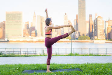 Schöne sportliche Frau macht Yoga-Meditation in einem Park - Mädchen entspannt mit heiterem Ausdruck im Freien - DMDF03305