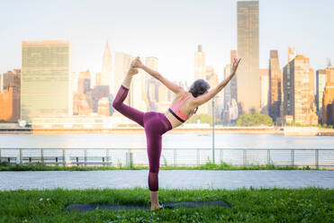 Schöne sportliche Frau macht Yoga-Meditation in einem Park - Mädchen entspannt mit heiterem Ausdruck im Freien - DMDF03306