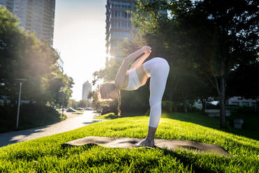 Schöne sportliche Frau macht Yoga-Meditation in einem Park - Mädchen entspannt mit heiterem Ausdruck im Freien - DMDF03319