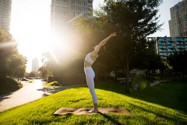 Schöne sportliche Frau macht Yoga-Meditation in einem Park - Mädchen entspannt mit heiterem Ausdruck im Freien - DMDF03330