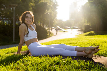 Schöne sportliche Frau macht Yoga-Meditation in einem Park - Mädchen entspannt mit heiterem Ausdruck im Freien - DMDF03335