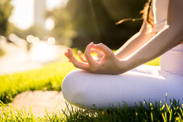 Schöne sportliche Frau macht Yoga-Meditation in einem Park - Mädchen entspannt mit heiterem Ausdruck im Freien - DMDF03342