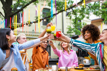 Multiracial young people together meeting and having party in a restaurant - Group of friends with mixed races having fun celebrating in a bar- Friendship and lifestyle concepts - DMDF03416