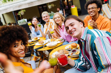 Multiracial young people together meeting and having party in a restaurant - Group of friends taking selfie while celebrating in a bar- Friendship and lifestyle concepts - DMDF03421