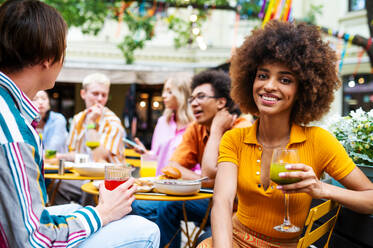 Multiracial young people together meeting and having party in a restaurant - Group of friends with mixed races having fun celebrating in a bar- Friendship and lifestyle concepts - DMDF03422