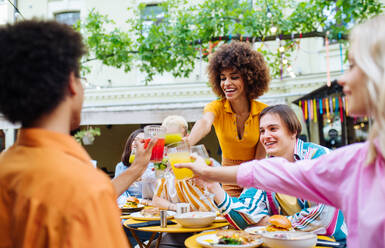 Multiracial young people together meeting and having party in a restaurant - Group of friends with mixed races having fun celebrating in a bar- Friendship and lifestyle concepts - DMDF03428