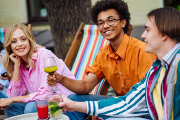 Multiracial young people together meeting and having party in a restaurant - Group of friends with mixed races having fun celebrating in a bar- Friendship and lifestyle concepts - DMDF03436