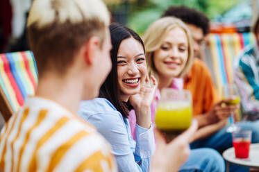 Multiracial young people together meeting and having party in a restaurant - Group of friends with mixed races having fun celebrating in a bar- Friendship and lifestyle concepts - DMDF03437