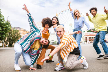 Multiracial young people together meeting and social gathering - Group of friends with mixed races having fun outdoors in the city- Friendship and lifestyle concepts - DMDF03471