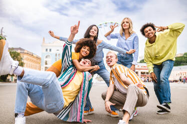 Multiracial young people together meeting and social gathering - Group of friends with mixed races having fun outdoors in the city- Friendship and lifestyle concepts - DMDF03473