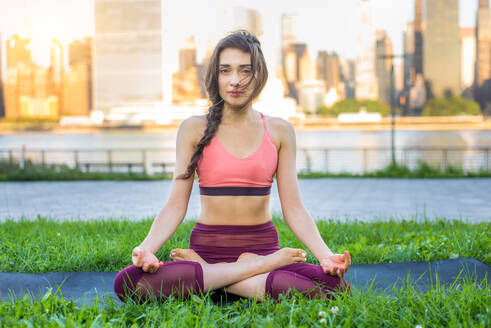 Schöne sportliche Frau macht Yoga-Meditation in einem Park - Mädchen entspannt mit heiterem Ausdruck im Freien - DMDF03521