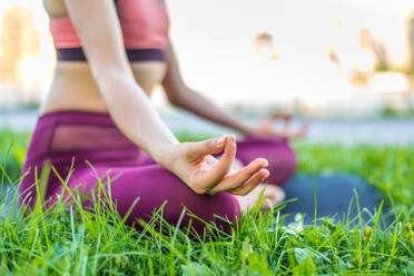 Schöne sportliche Frau macht Yoga-Meditation in einem Park - Mädchen entspannt mit heiterem Ausdruck im Freien - DMDF03528