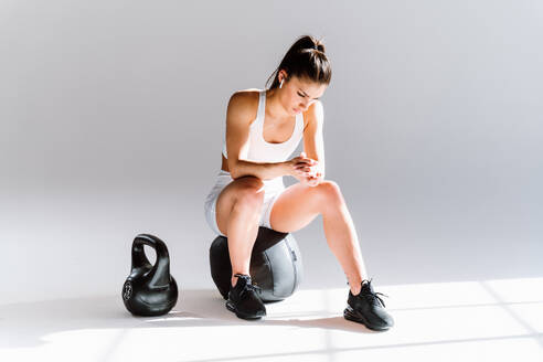 Young female athlete training in a gym using sport equipment. Fit woman working out . Concept about fitness, wellness and sport preparation. - DMDF03573