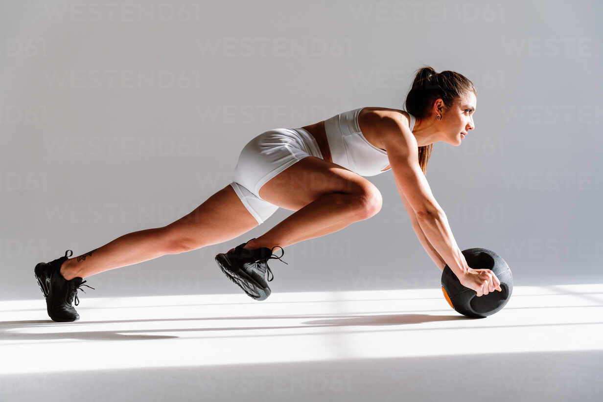 Woman in Stylish Sports Wear Training with Med Ball Stock Photo