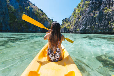 Frau beim Kajakfahren in der kleinen Lagune in El Nido, Palawan, Philippinen - Reisebloggerin erkundet die besten Orte Südostasiens - DMDF03605