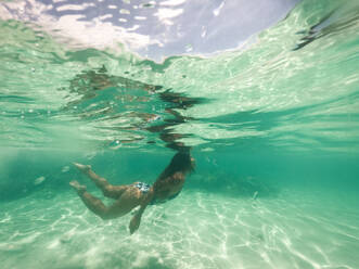 Frau schwimmt unter Wasser an einem tropischen Strand mit blauem Wasser und Palmen - El Nido, Palawan, Philippinen - DMDF03607