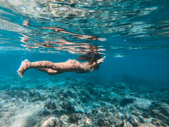 Frau beim Tauchen an einem tropischen Strand mit blauem Wasser und Palmen - El Nido, Palawan, Philippinen - DMDF03610