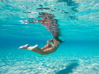 Frau schwimmt unter Wasser an einem tropischen Strand mit blauem Wasser und Palmen - El Nido, Palawan, Philippinen - DMDF03613