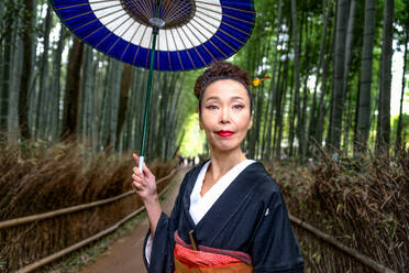 Asiatische Frau im traditionellen japanischen Kimono im Bambuswald in Kyoto, Japan - DMDF03636