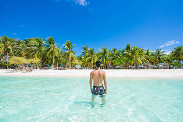 Tourist an einem tropischen Strand mit blauem Wasser und Palmen - Coron, Philippinen - DMDF03659