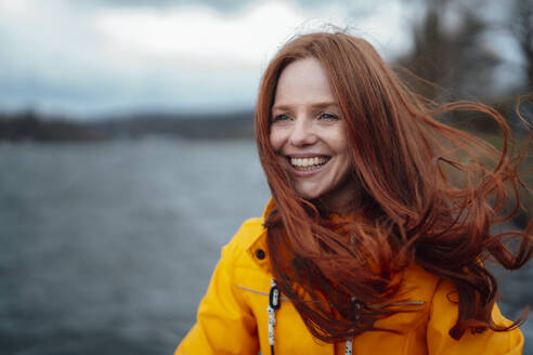 Happy redhead woman wearing yellow jacket - KNSF09752