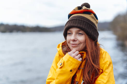 Contemplative redhead woman wearing knit hat - KNSF09763