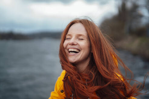 Redhead woman laughing and enjoying at lake - KNSF09778