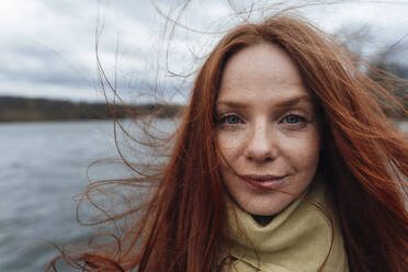 Redhead woman with long hair by lake - KNSF09796
