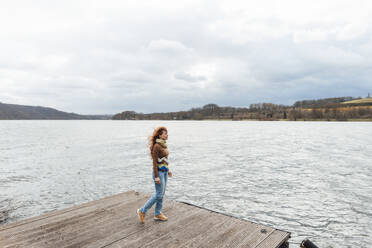 Frau verbringt ihre Freizeit auf einem Steg am See - KNSF09804