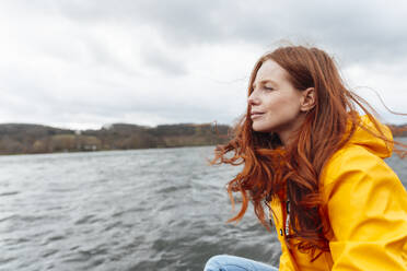 Thoughtful redhead woman looking at lake - KNSF09816