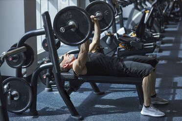 Älterer Mann beim Bankdrücken im Fitnessstudio - KPEF00192