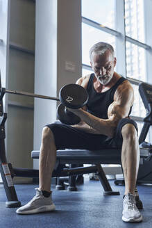 Älterer Mann macht Bizepsübungen im Fitnessstudio - KPEF00202