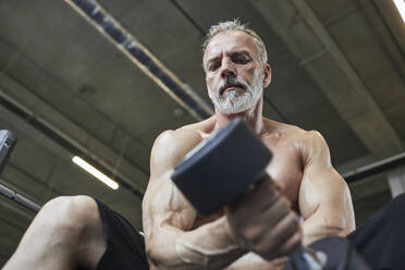 Älterer Mann beim Hanteltraining im Fitnessstudio - KPEF00236