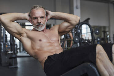 Shirtless reifen Mann tun curl up Übung in der Turnhalle - KPEF00240