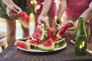 Hände von Freunden halten Scheiben von Wassermelone am Tisch - ANNF00419