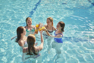 Glückliche Freunde stoßen zusammen an und haben Spaß im Schwimmbad - ANNF00437